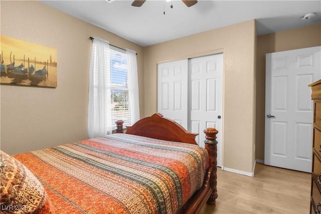 bedroom with ceiling fan, light wood-style floors, a closet, and baseboards