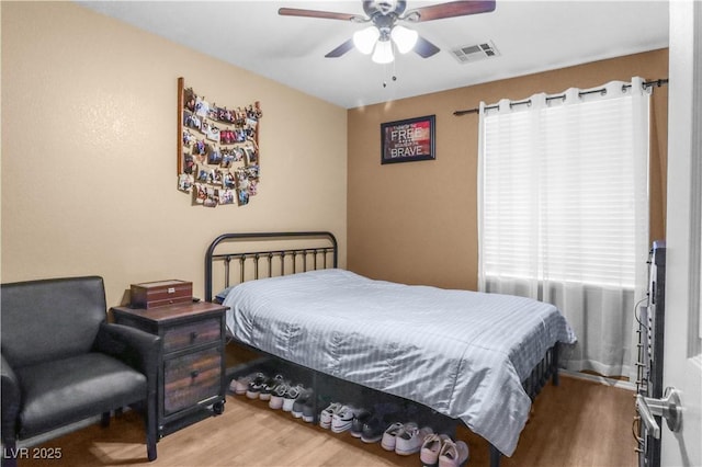 bedroom featuring visible vents, ceiling fan, and wood finished floors