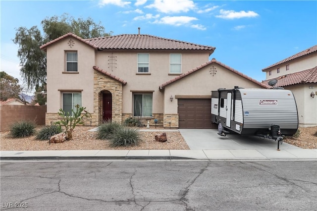 mediterranean / spanish home with stone siding, stucco siding, concrete driveway, and a garage