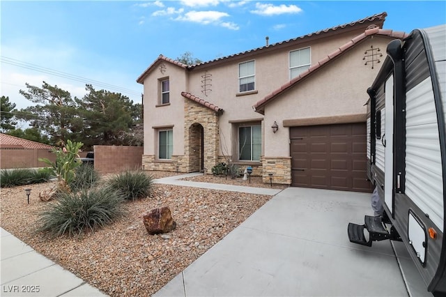 mediterranean / spanish-style house with fence, concrete driveway, stucco siding, stone siding, and an attached garage