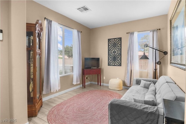 living area with visible vents, plenty of natural light, and baseboards