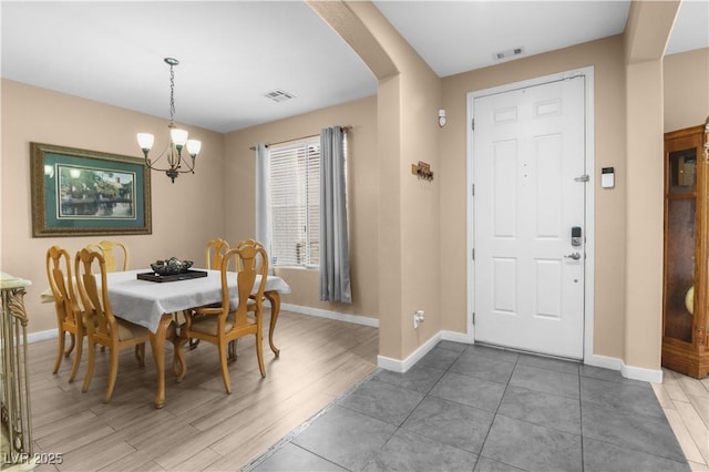 dining space featuring arched walkways, visible vents, and baseboards