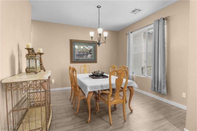 dining space with baseboards, light wood-style floors, visible vents, and a healthy amount of sunlight