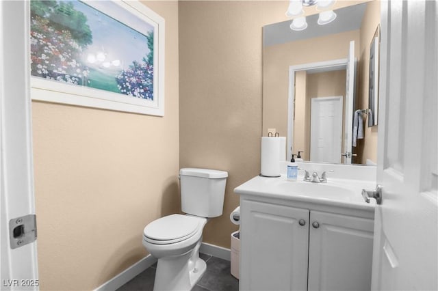 half bath featuring tile patterned floors, toilet, vanity, and baseboards