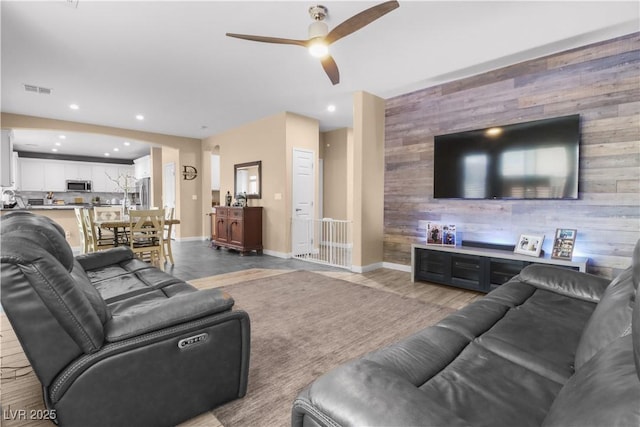 living room featuring visible vents, recessed lighting, an accent wall, and baseboards