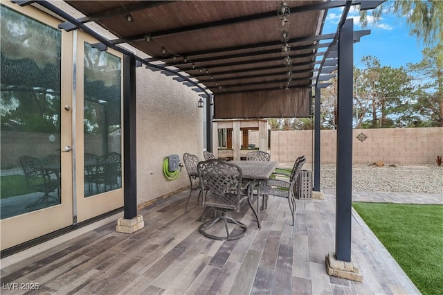 view of patio / terrace featuring outdoor dining area, fence, a pergola, and french doors