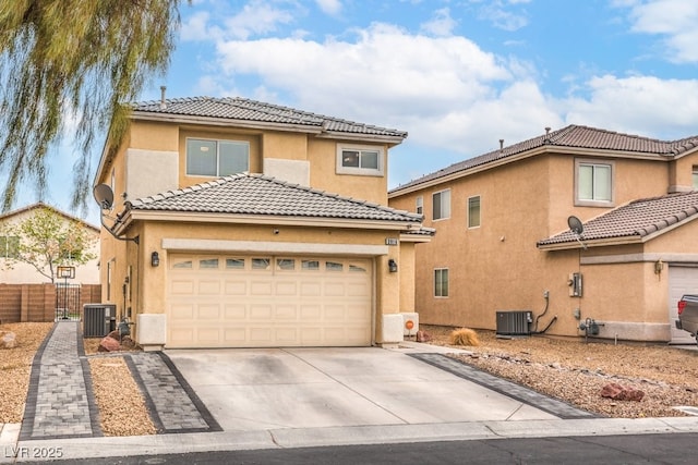 view of front of property featuring fence, central air condition unit, concrete driveway, a tile roof, and stucco siding