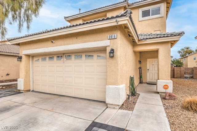 view of front of house with concrete driveway, a tiled roof, fence, and stucco siding