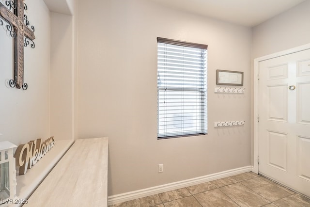 foyer entrance with light tile patterned floors and baseboards