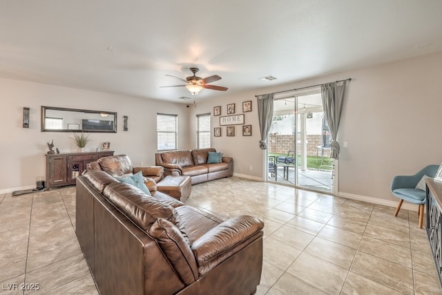 living room with light tile patterned floors, visible vents, baseboards, and ceiling fan