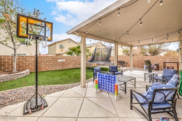 view of patio featuring a trampoline and a fenced backyard