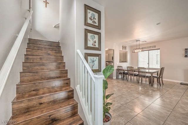 stairs featuring baseboards and tile patterned flooring