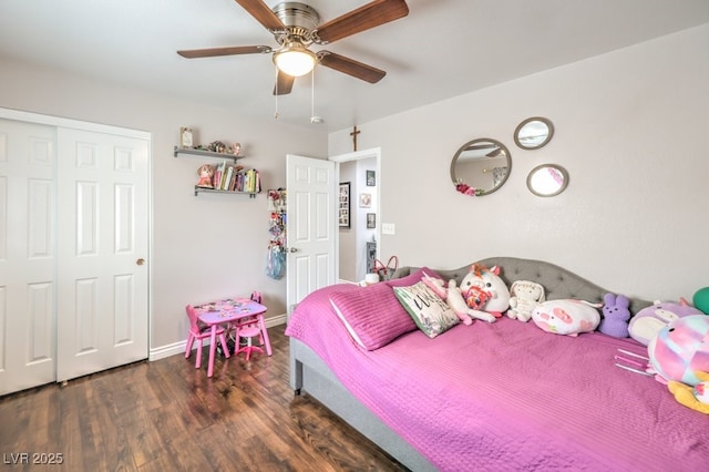 bedroom with a ceiling fan, wood finished floors, a closet, and baseboards