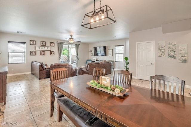 dining room with light tile patterned floors, visible vents, baseboards, and a ceiling fan