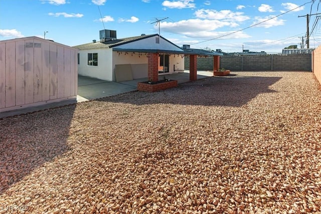 view of yard with a patio area, central AC, an outbuilding, and a fenced backyard