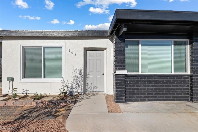 entrance to property featuring stucco siding