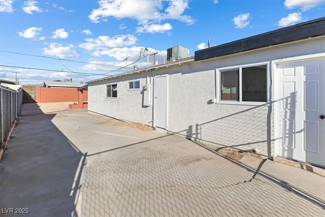 rear view of property featuring stucco siding, a patio, and a fenced backyard