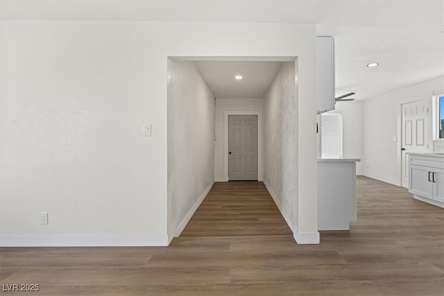 hallway featuring recessed lighting, baseboards, and wood finished floors