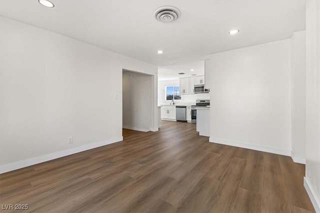 unfurnished living room featuring recessed lighting, visible vents, baseboards, and dark wood-style floors