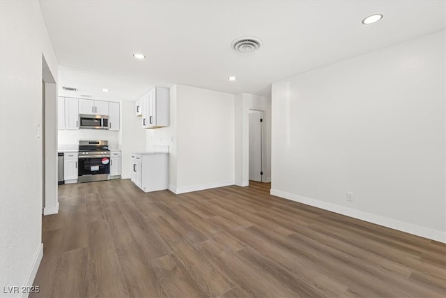 unfurnished living room featuring recessed lighting, dark wood-type flooring, and baseboards