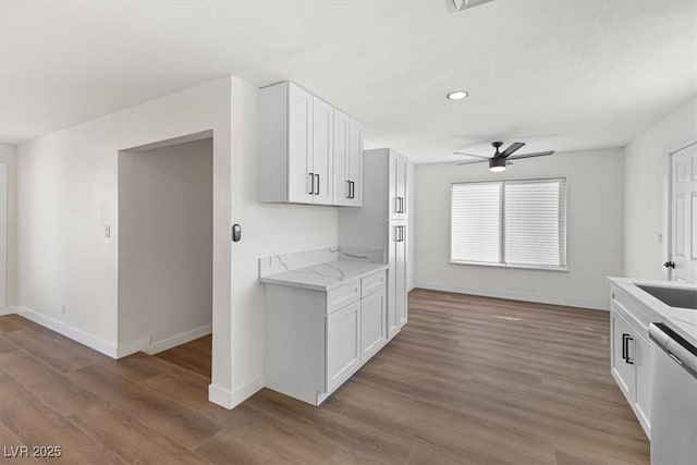 kitchen featuring ceiling fan, dishwasher, wood finished floors, and white cabinetry