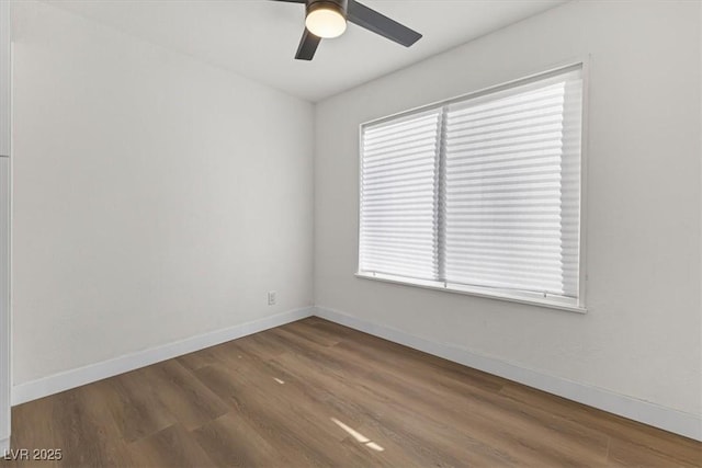 spare room with a ceiling fan, wood finished floors, and baseboards