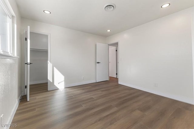 unfurnished bedroom featuring recessed lighting, visible vents, baseboards, and wood finished floors