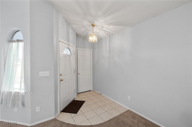 foyer with light carpet, baseboards, and a chandelier