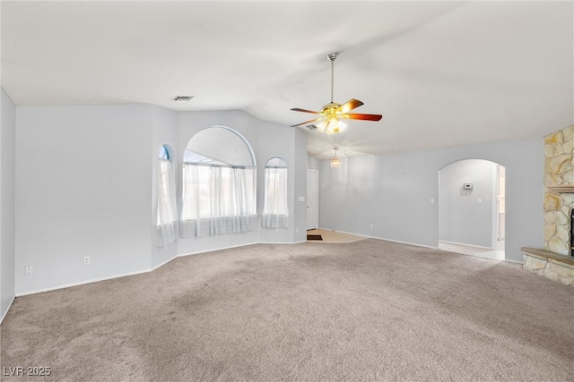 unfurnished living room featuring visible vents, a ceiling fan, arched walkways, carpet flooring, and lofted ceiling