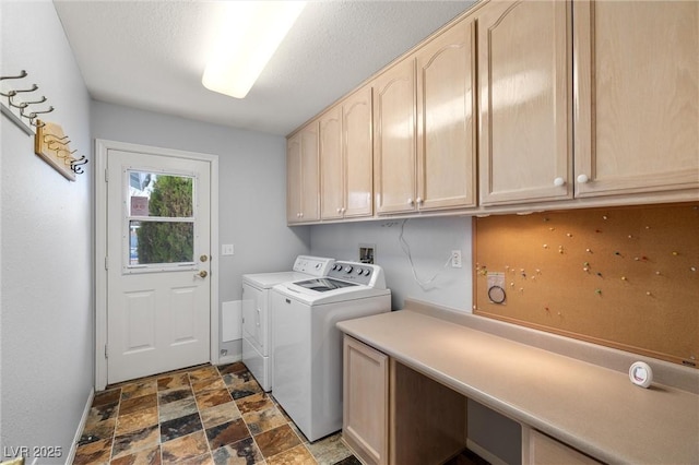 laundry area featuring stone finish floor, cabinet space, baseboards, and washer and clothes dryer