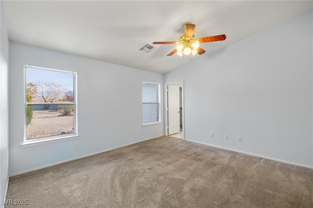 carpeted empty room featuring vaulted ceiling, a ceiling fan, visible vents, and baseboards