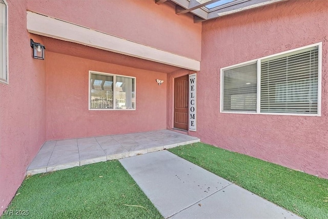 entrance to property with stucco siding