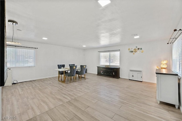dining space with healthy amount of natural light, light wood finished floors, baseboards, and recessed lighting