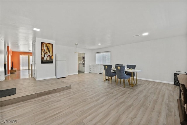 dining space featuring light wood finished floors, plenty of natural light, baseboards, and recessed lighting