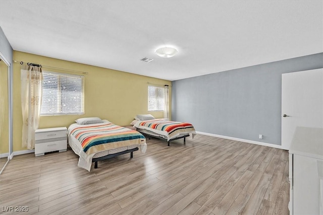 bedroom featuring light wood finished floors and baseboards