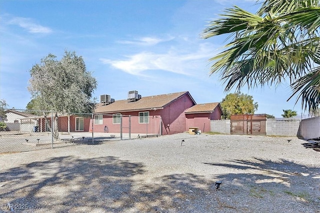 back of house featuring central air condition unit and fence