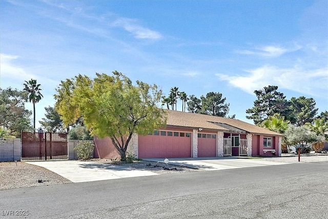 view of front facade featuring a garage, fence, and driveway