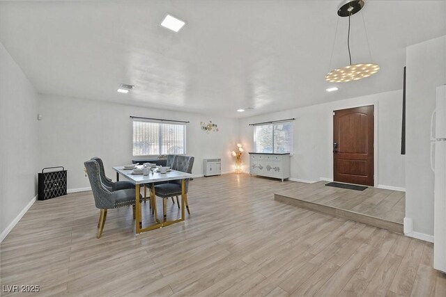 dining room featuring light wood-type flooring and baseboards