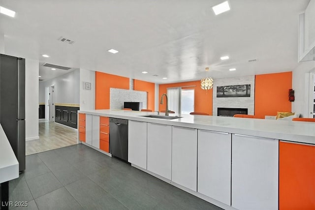 kitchen with a fireplace, a sink, dishwashing machine, open floor plan, and recessed lighting