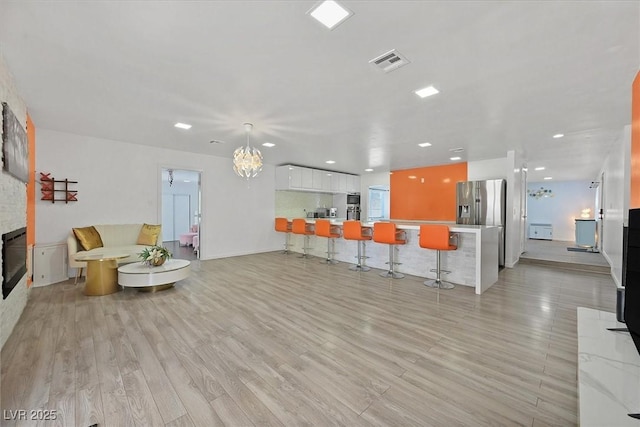 living room with light wood-style floors and recessed lighting