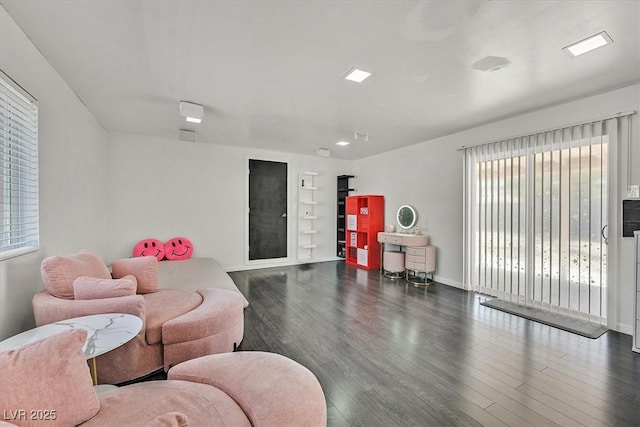 living area featuring wood finished floors, built in features, and baseboards