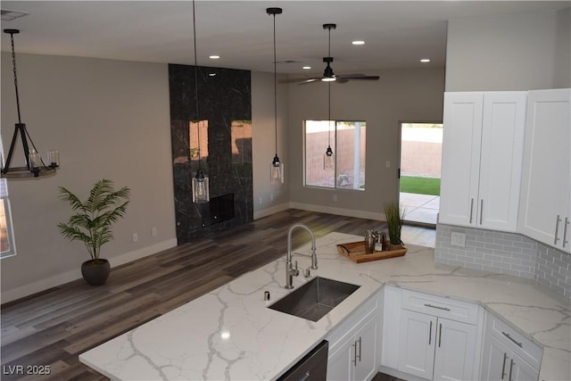 kitchen featuring dark wood-style floors, white cabinetry, tasteful backsplash, and a sink