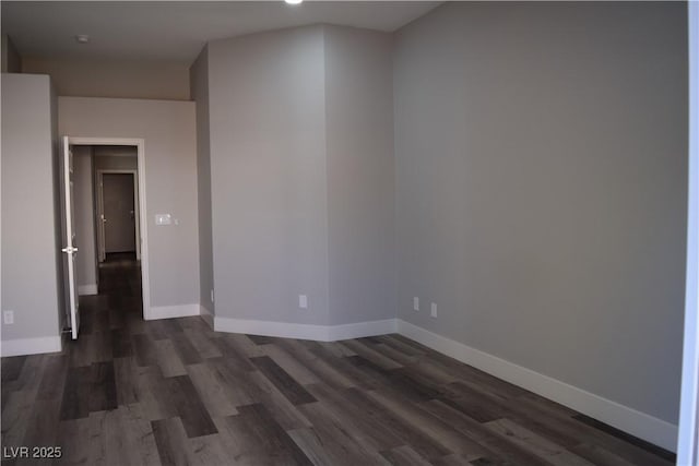 unfurnished room with baseboards and dark wood-style flooring