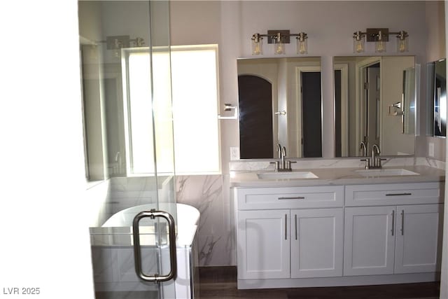 full bath featuring a sink, a freestanding bath, and double vanity