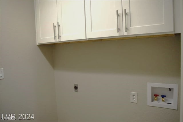 clothes washing area with cabinet space, hookup for an electric dryer, and washer hookup