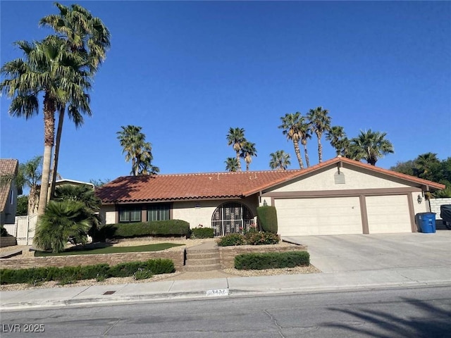 view of front of home featuring stucco siding, an attached garage, driveway, and a tile roof