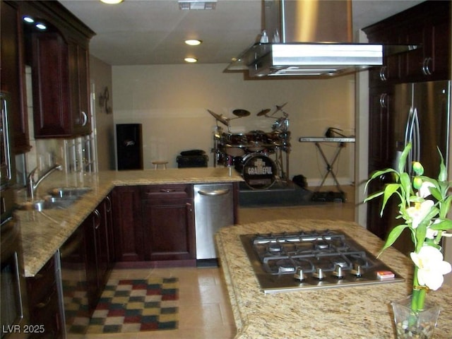 kitchen featuring light stone countertops, a peninsula, a sink, stainless steel appliances, and extractor fan