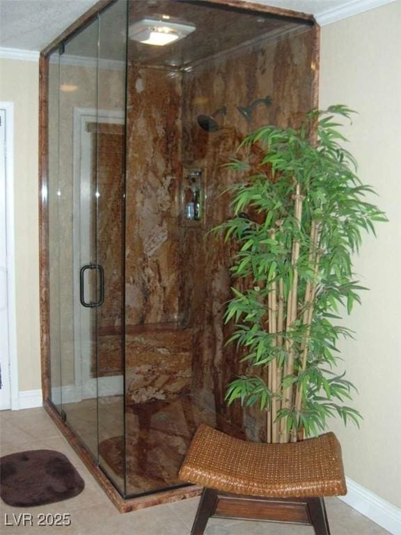 full bathroom featuring a shower stall, crown molding, and baseboards