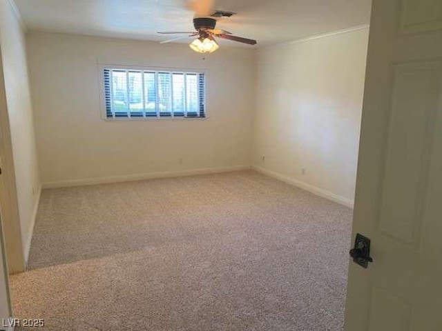 spare room with a ceiling fan, visible vents, baseboards, crown molding, and light colored carpet