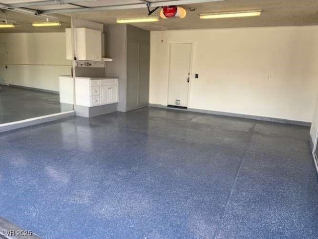 garage featuring a garage door opener and baseboards